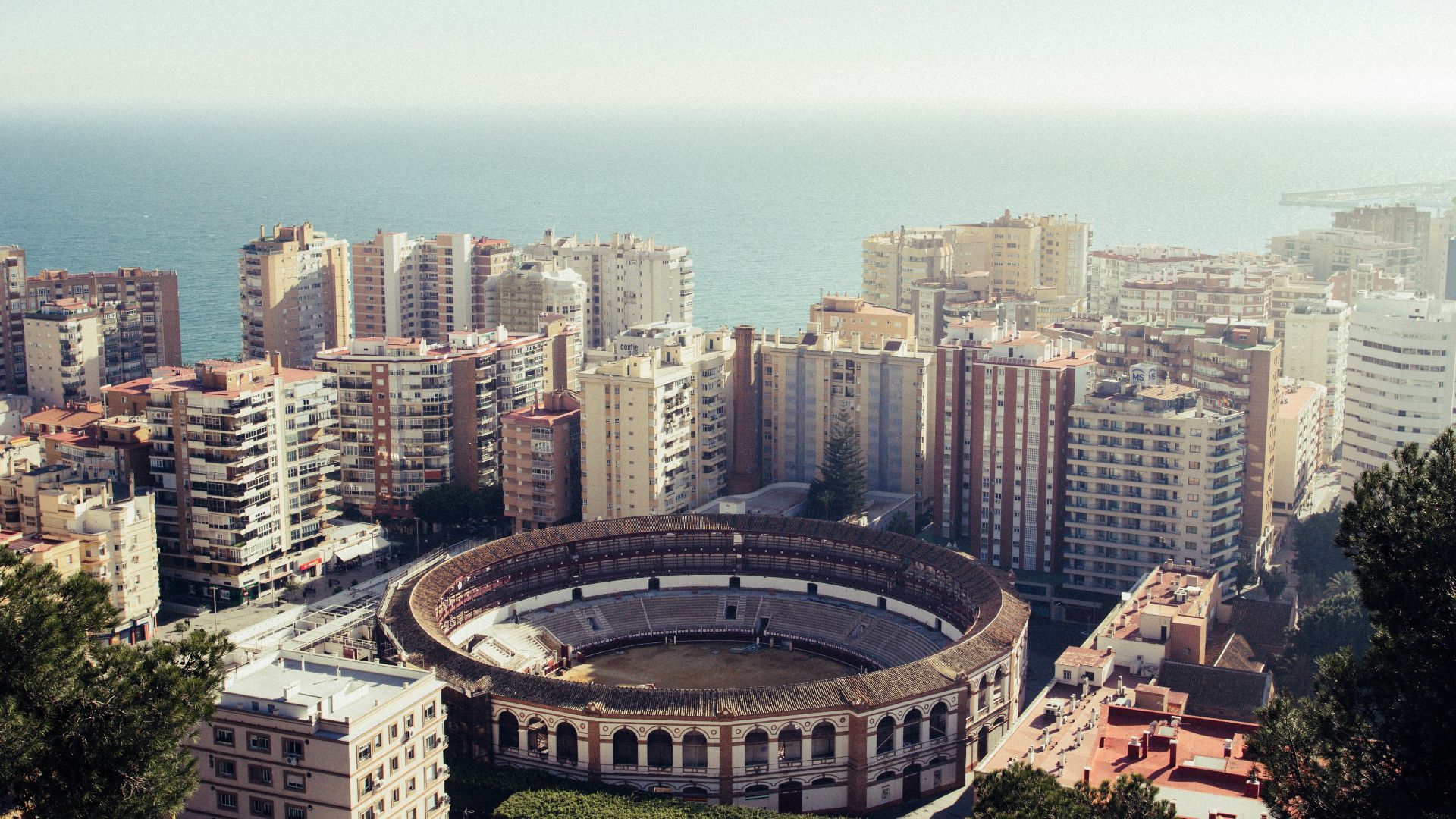 round stadium surrounded by buildings near the sea