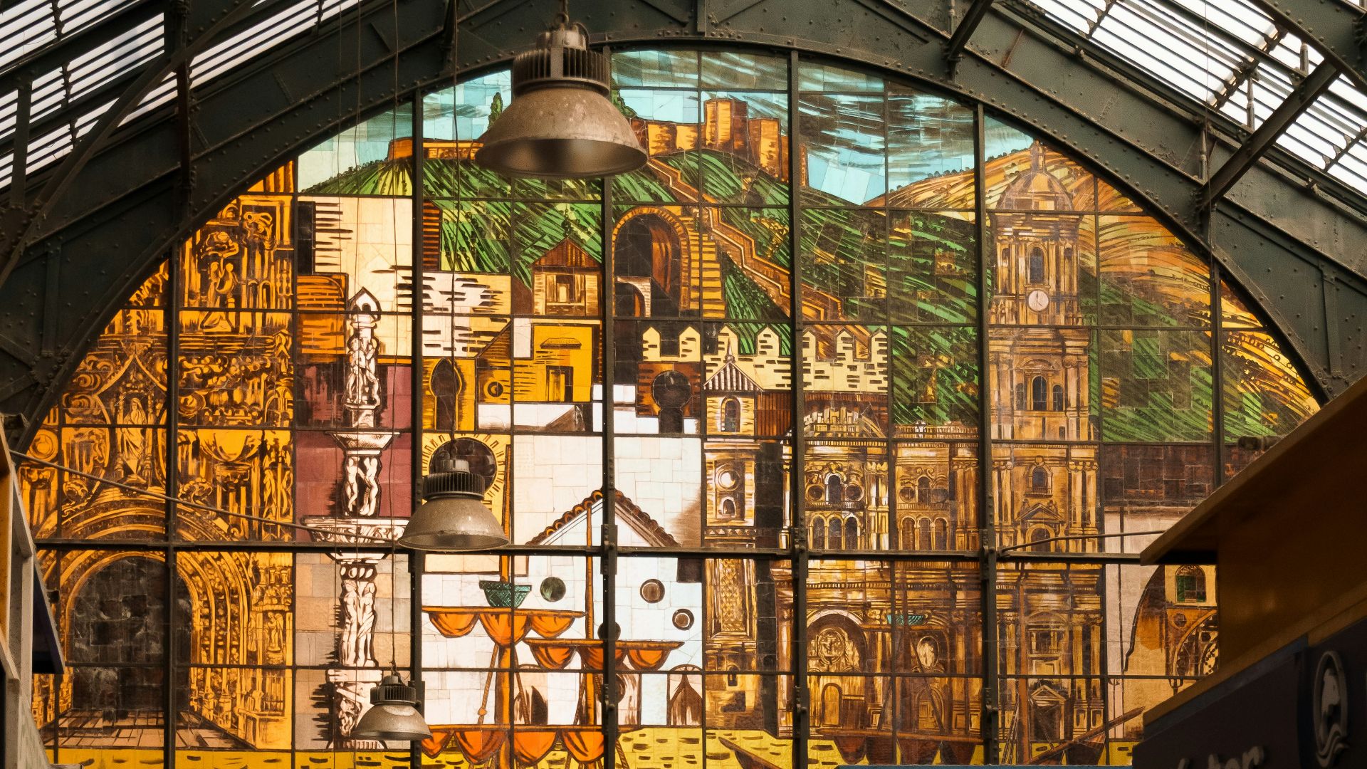 People walk through a market with stained-glass artwork.