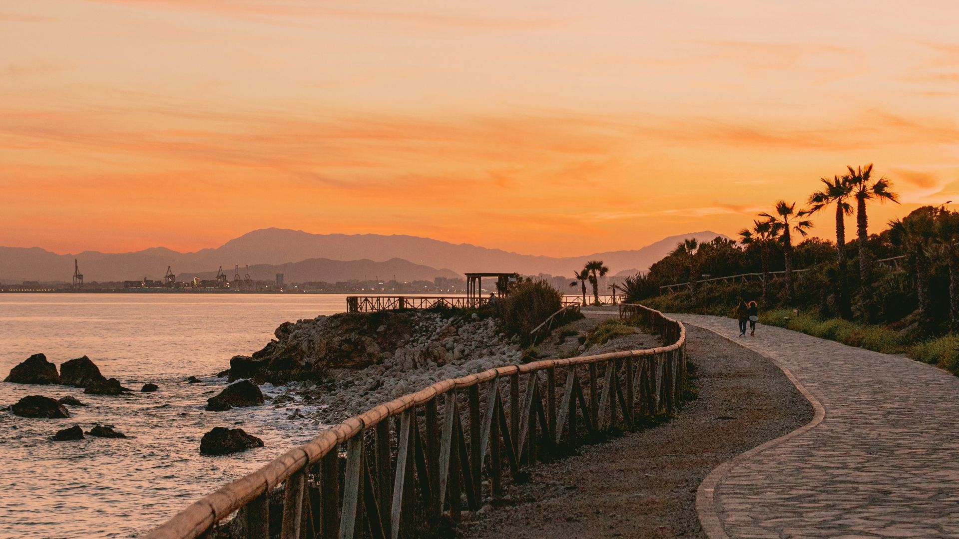 a person walking down a path next to a body of water