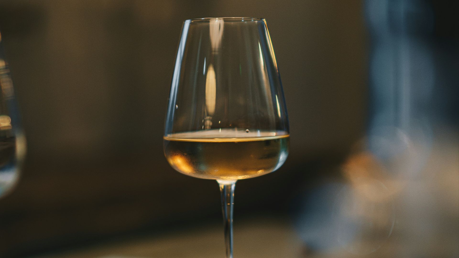 a glass of wine sitting on top of a table