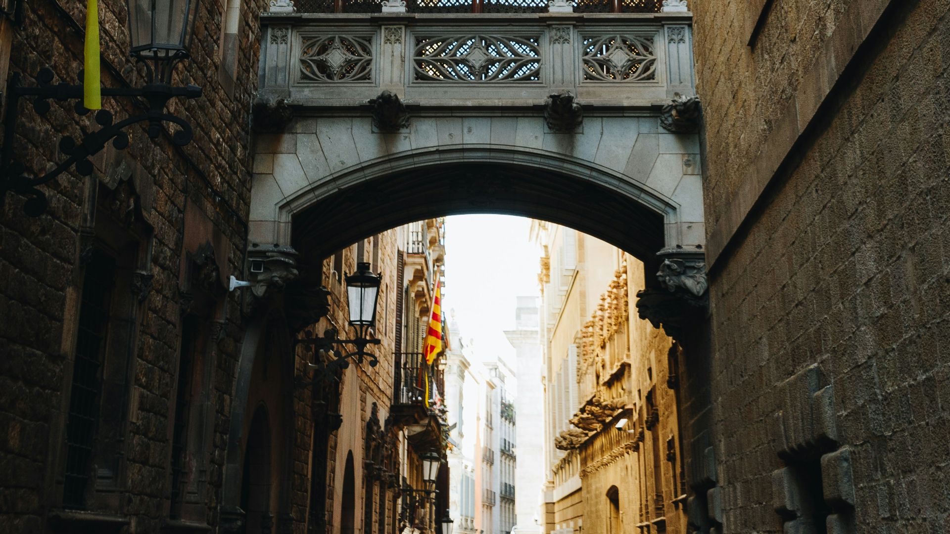 grey concrete archway in between two brown concrete buildings
