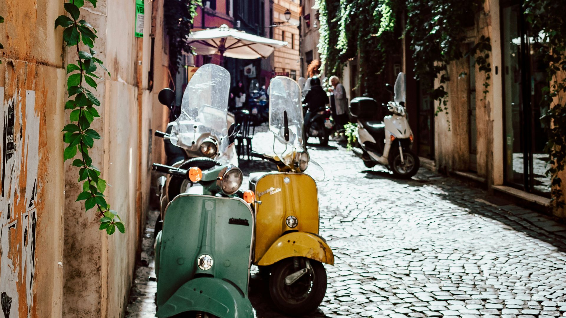 yellow and black motor scooter parked beside brown concrete building during daytime