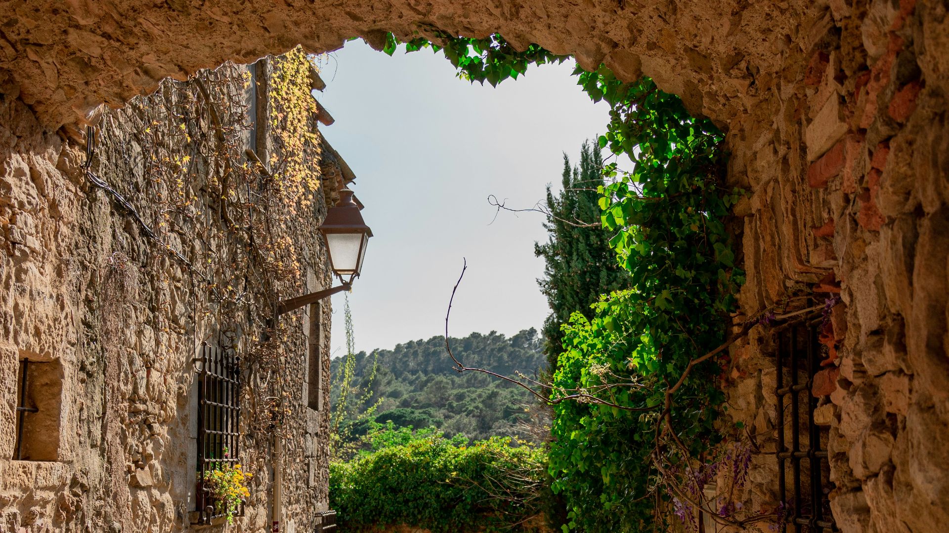 a narrow cobblestone street with a stone building in the background