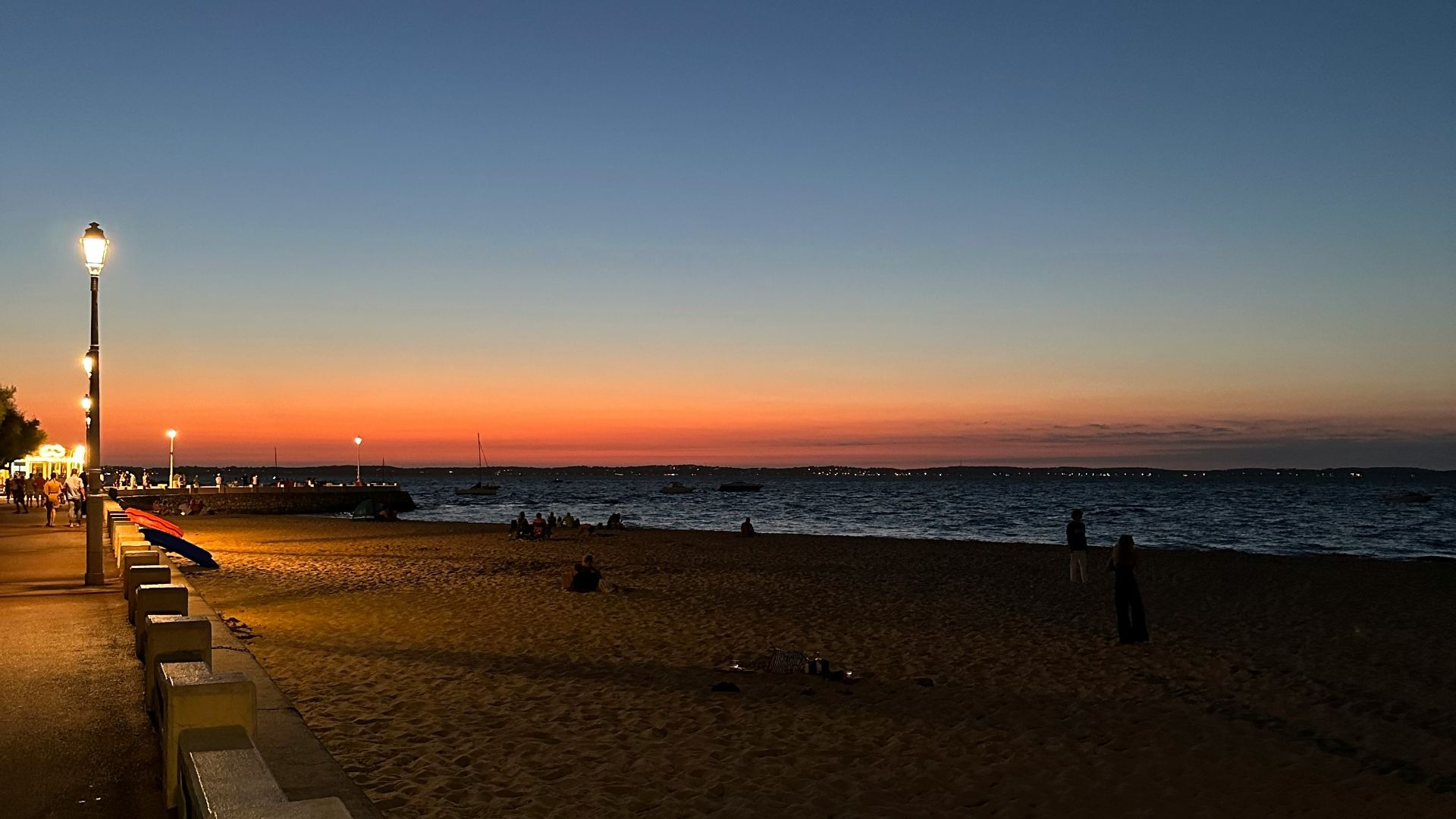 a bench sitting on top of a sandy beach next to the ocean