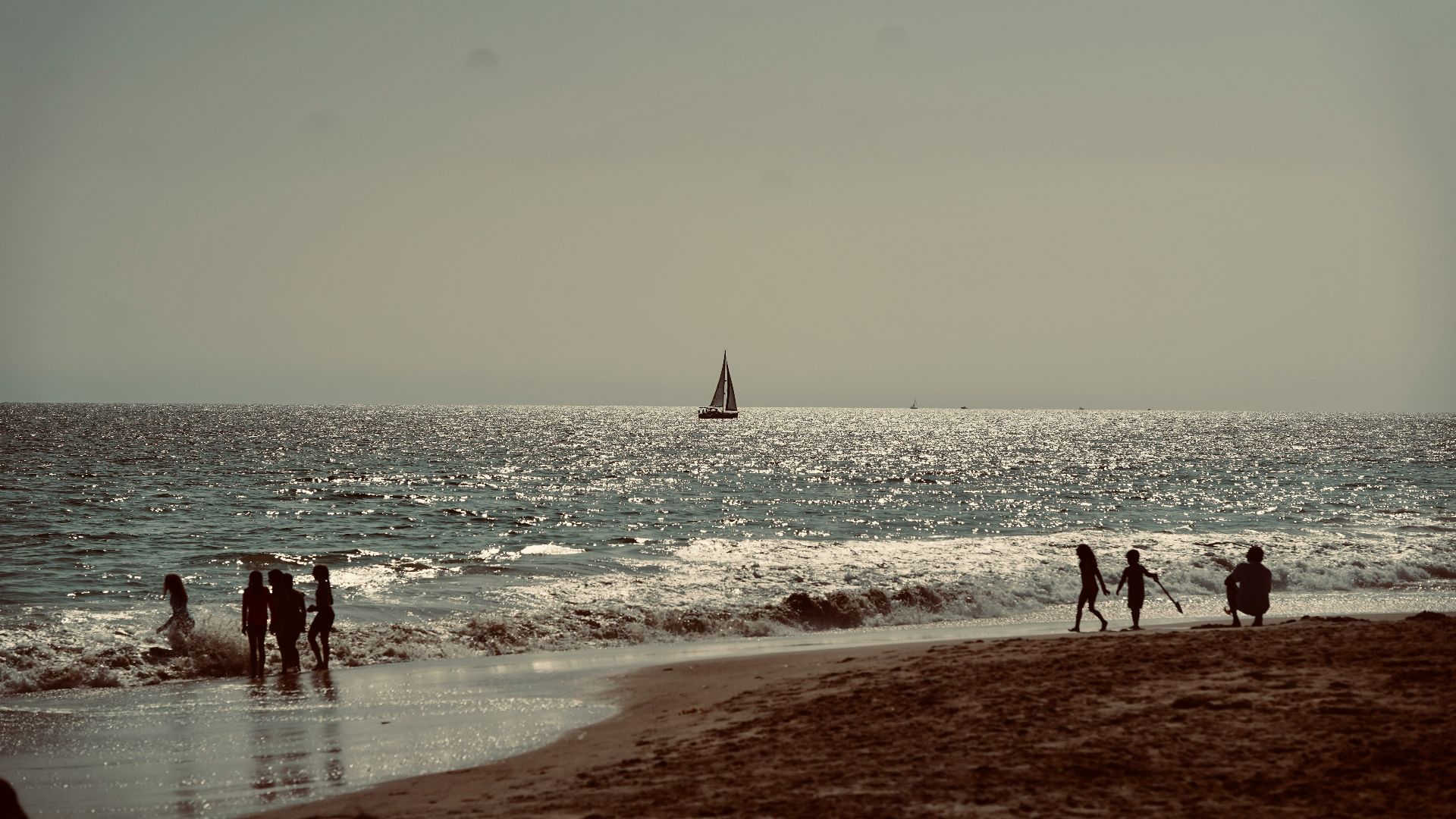 a group of people standing on top of a sandy beach