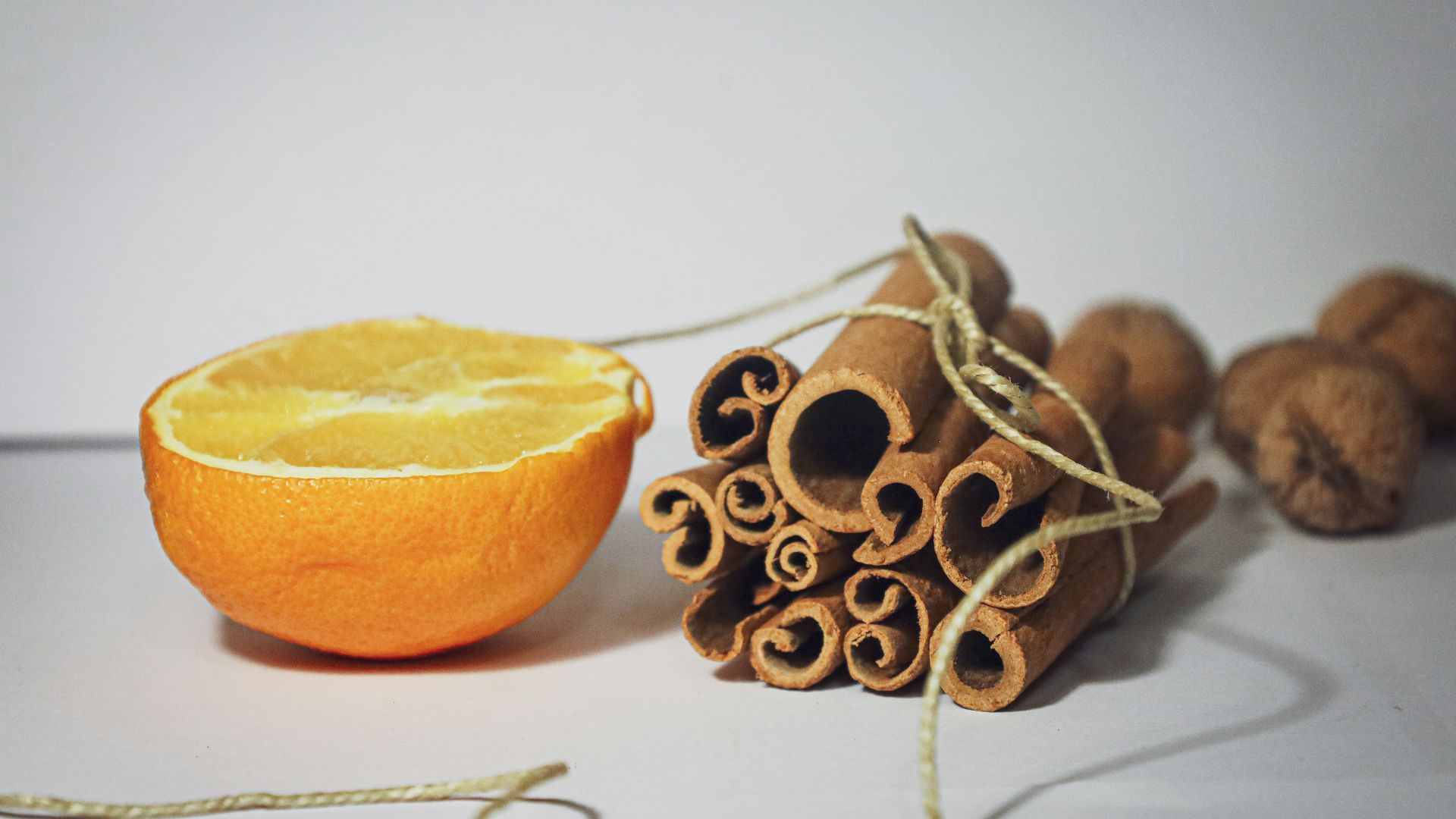 an orange and some cinnamons on a table