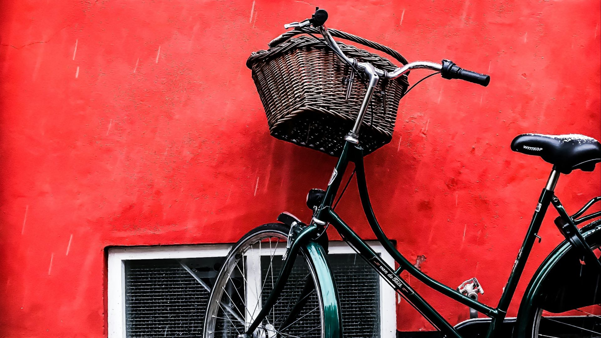 black cruiser bicycle beside red wall