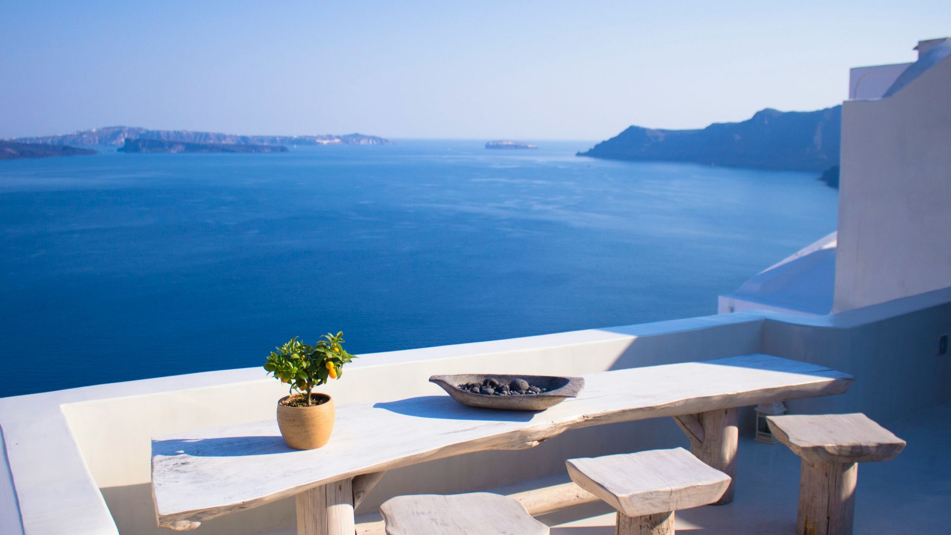 bench and dining table near body of water under calm sky