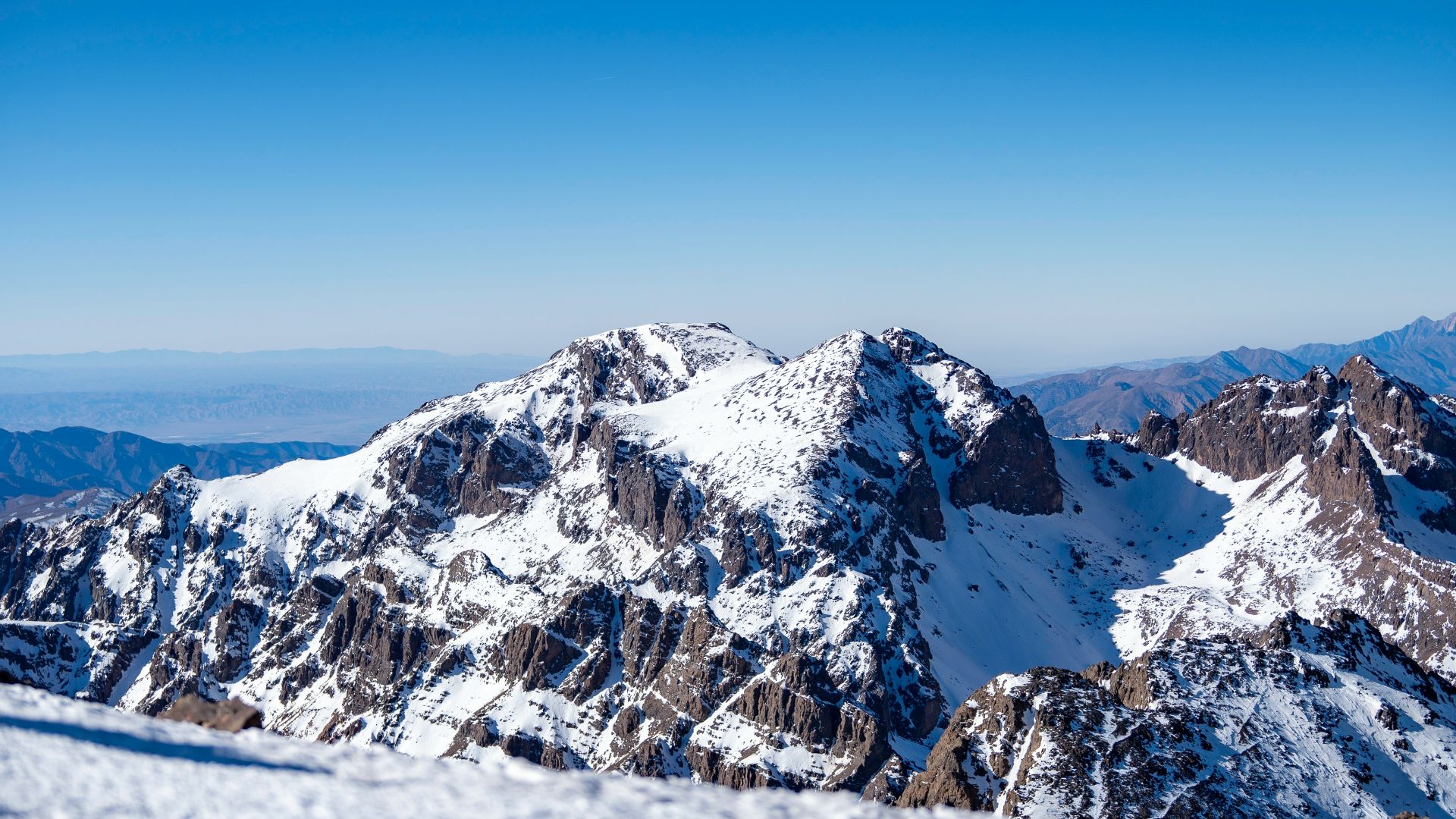 A snow covered mountain with a blue sky in the background