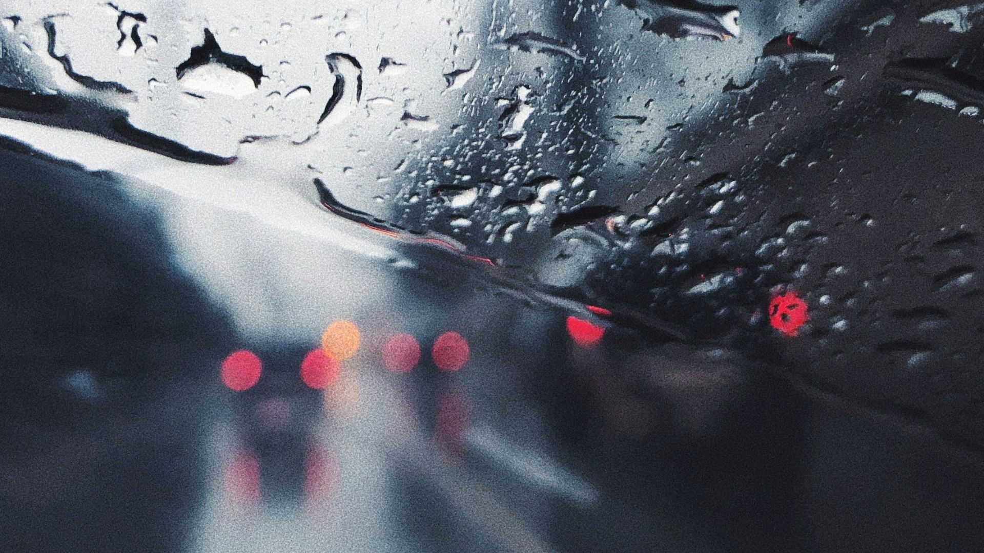 a view of a rain covered windshield from inside a car