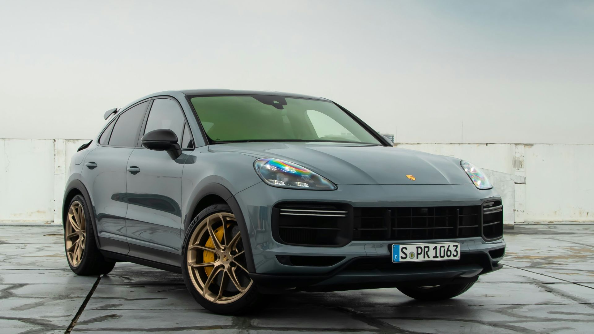 a grey porsche cayen is parked in a parking lot