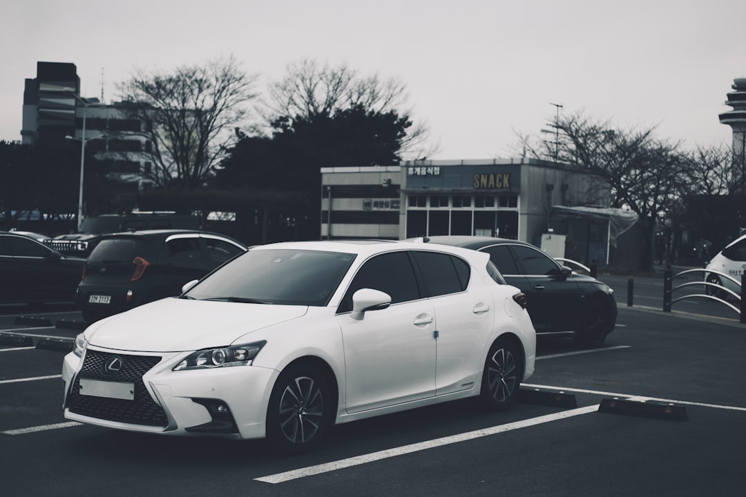 a white car is parked in a parking lot
