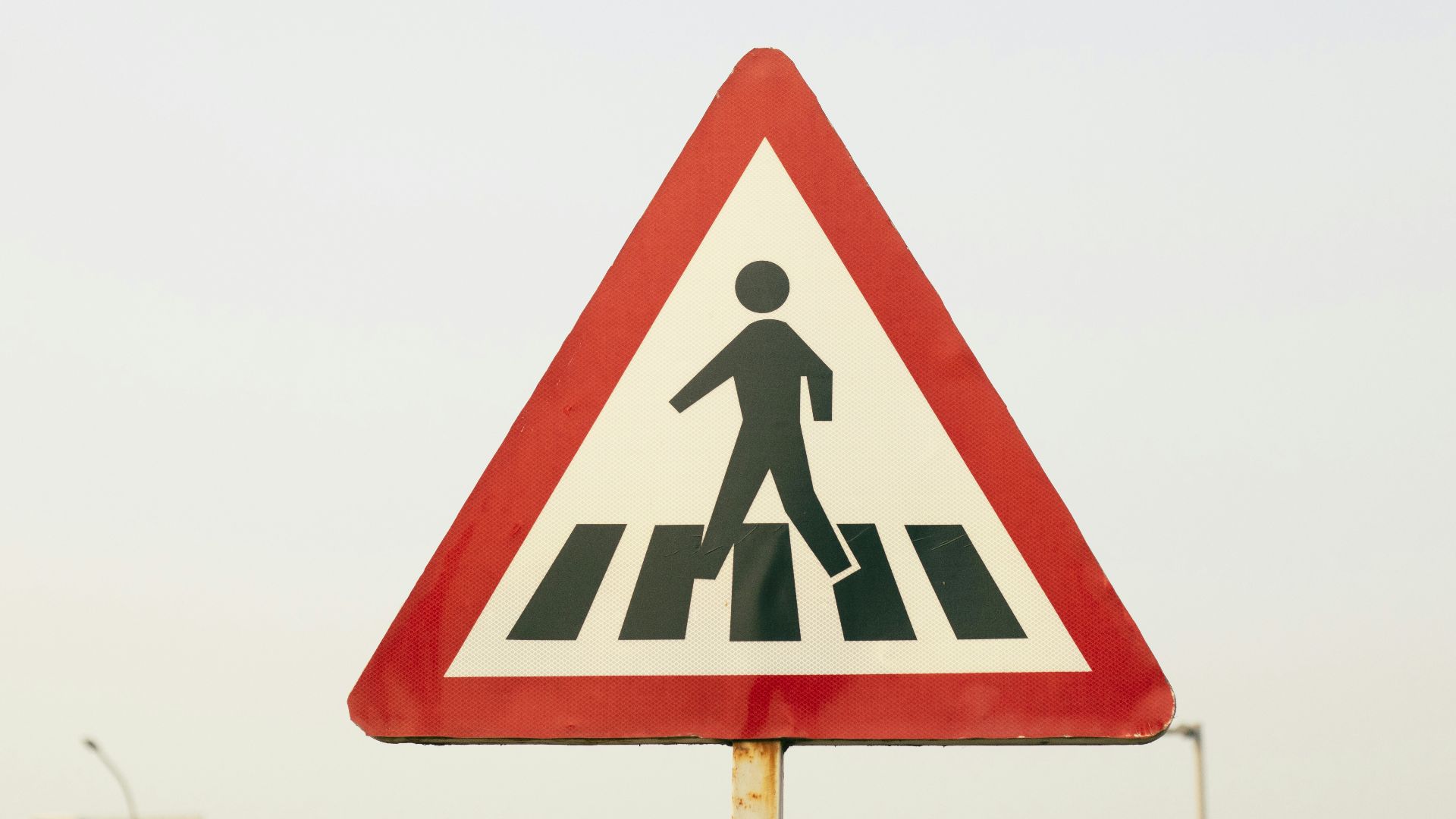 a pedestrian crossing sign on a city street