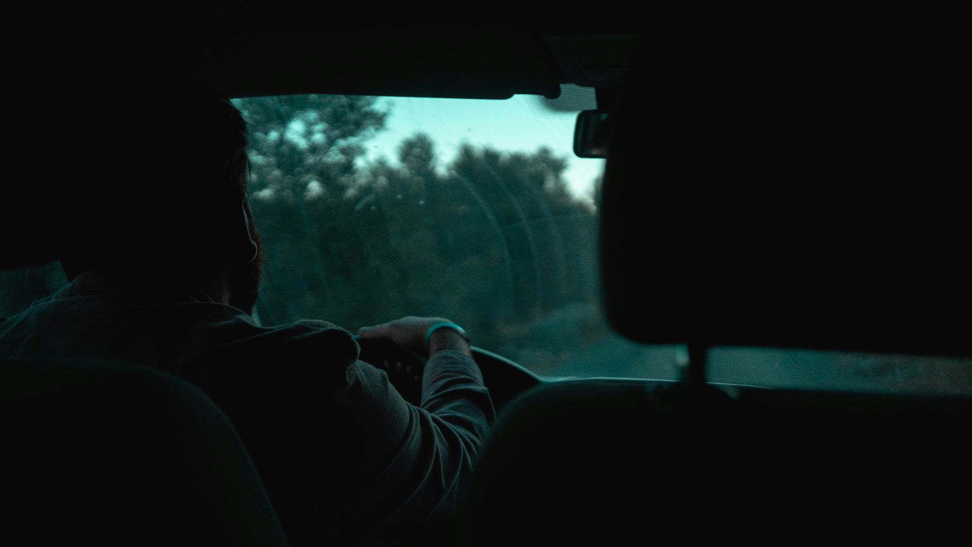 A person driving a car in the dark