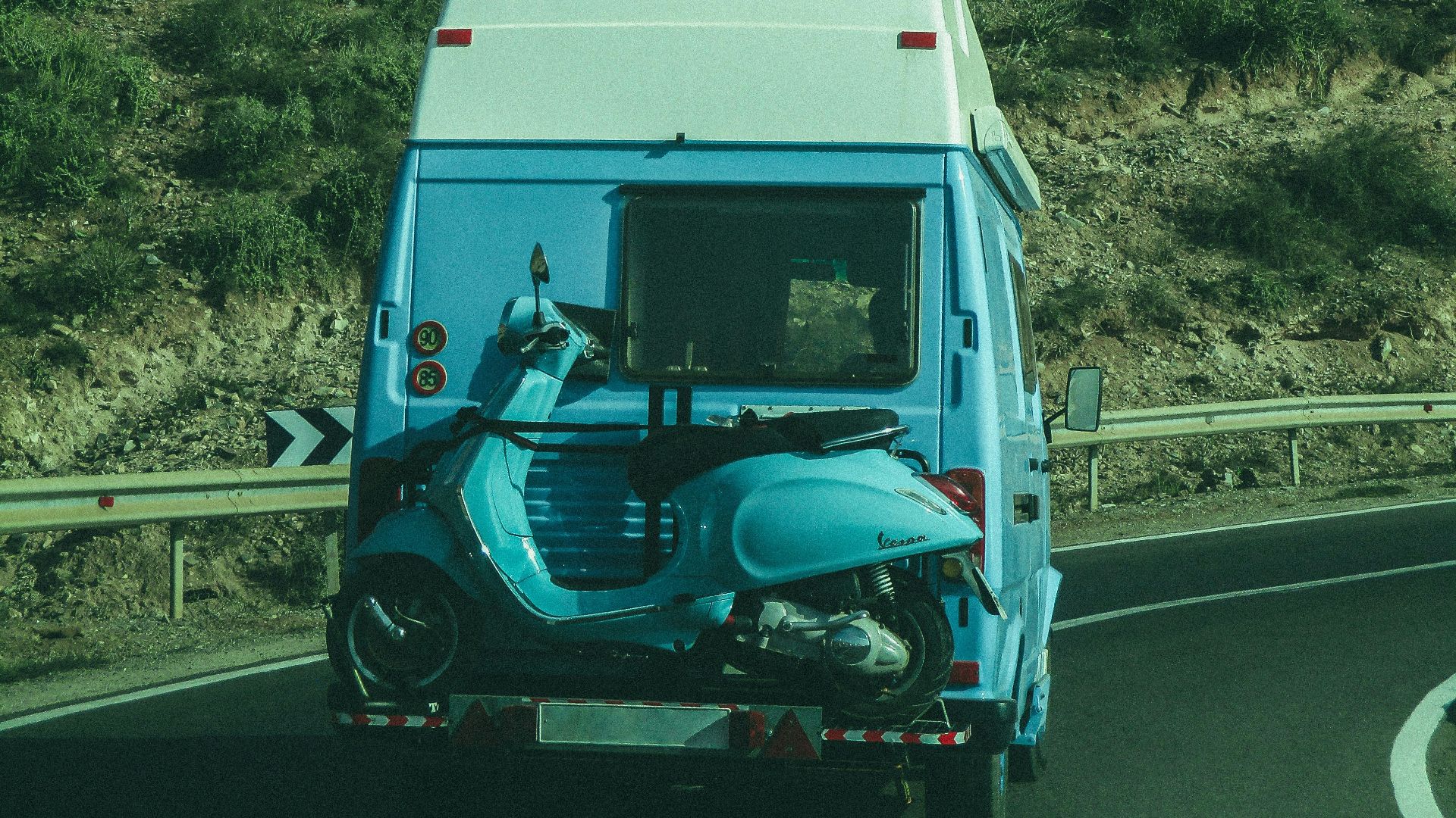 a blue and white truck driving down a road