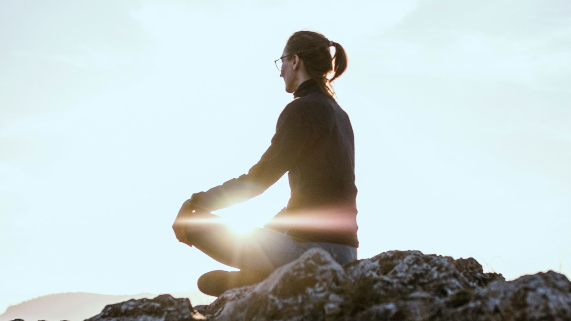 person sitting on rock formation during daytime