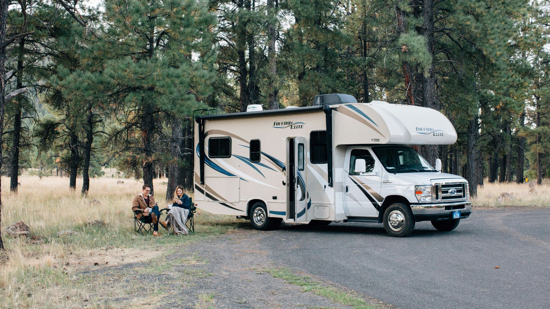 people standing near white rv trailer during daytime