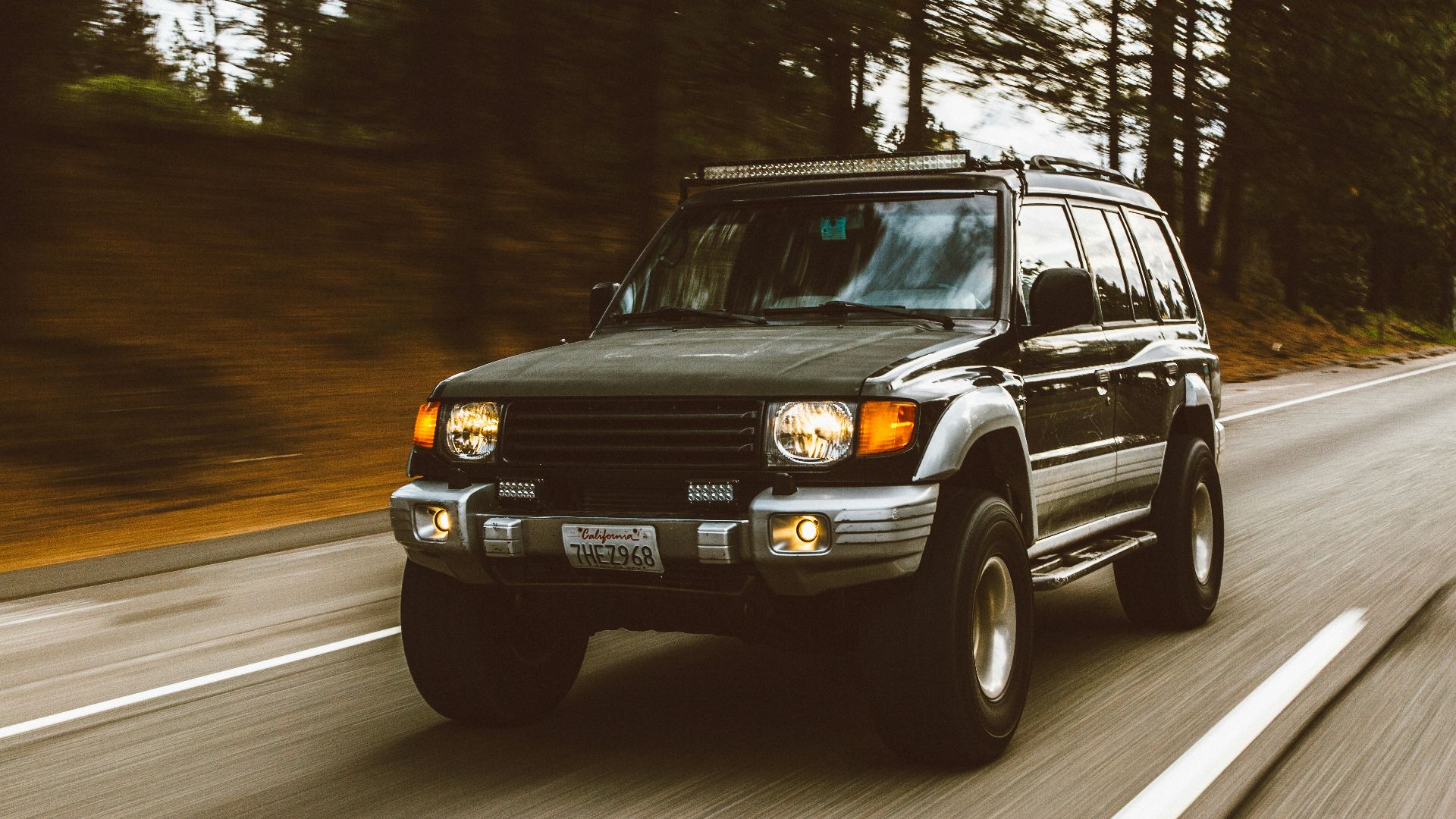 timelapse photography of green SUV on road