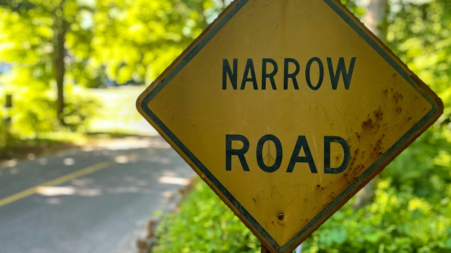 a yellow road sign sitting on the side of a road