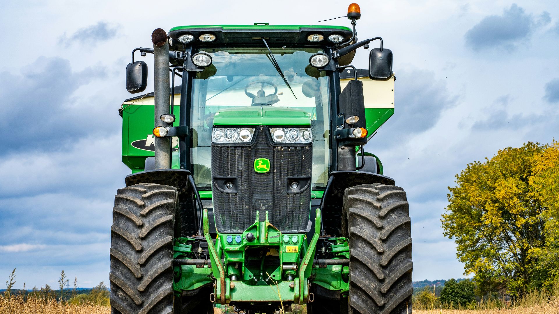 green and black tractor on brown grass field during daytime
