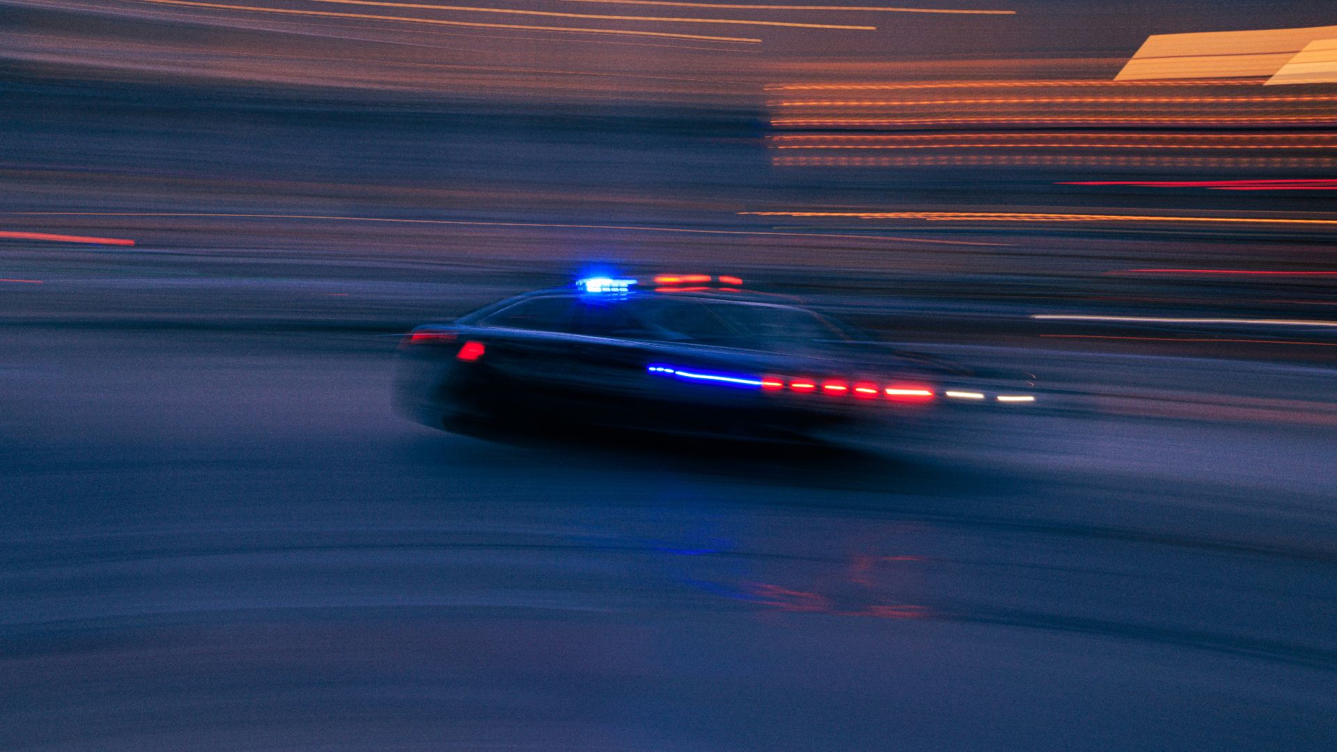 a police car driving down a street at night
