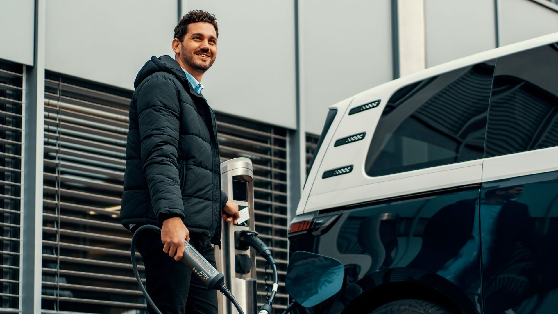 a man standing next to a blue car
