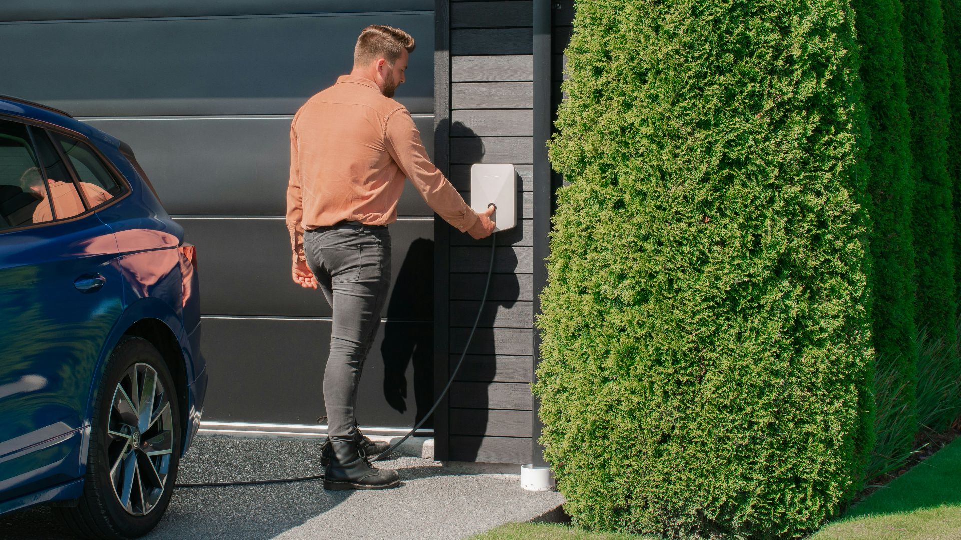 a man standing next to a blue car