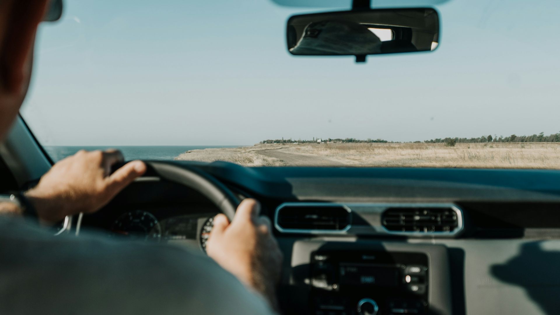 person driving car on road during daytime