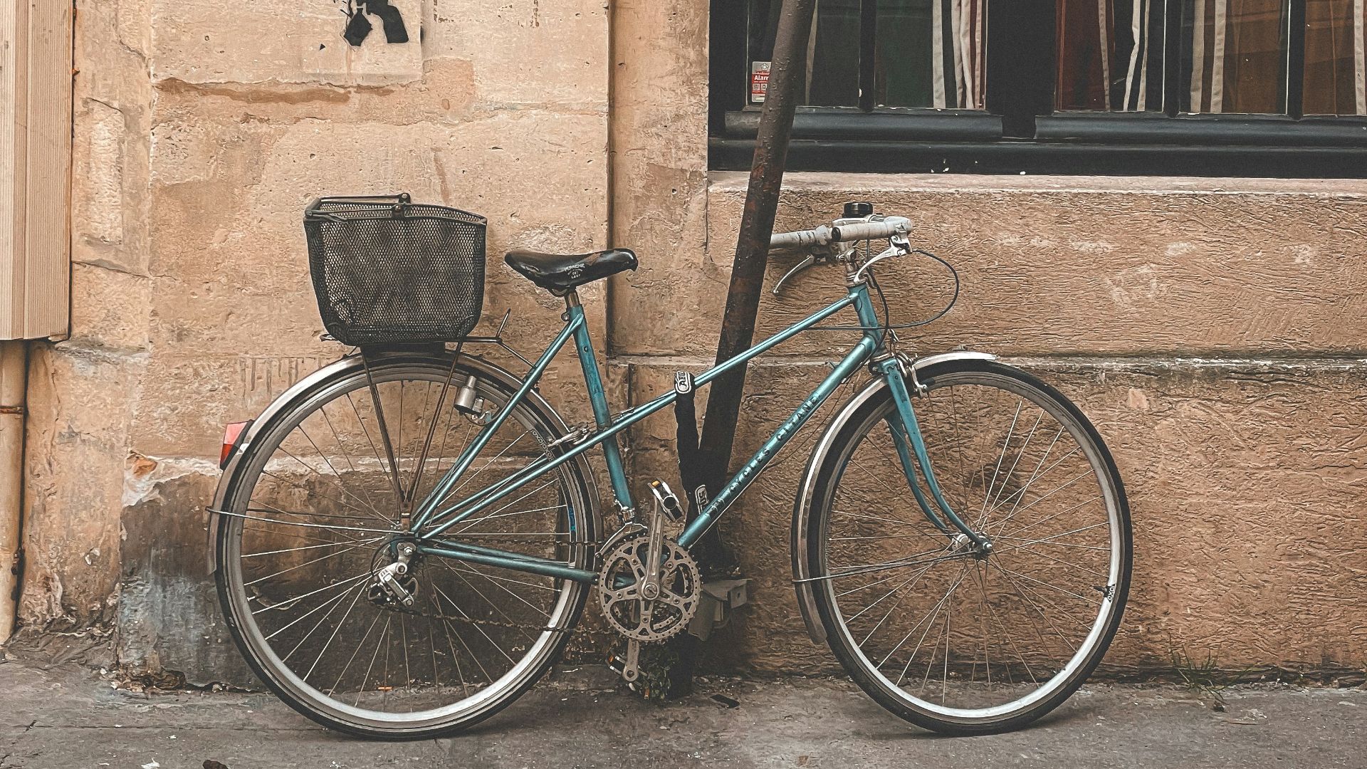 a blue bike parked next to a building