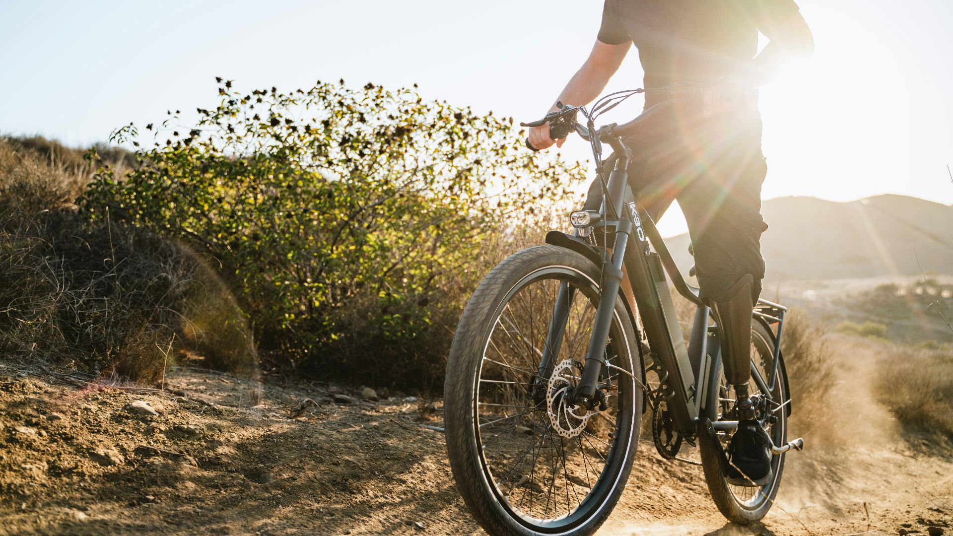 a man riding a bike down a dirt road