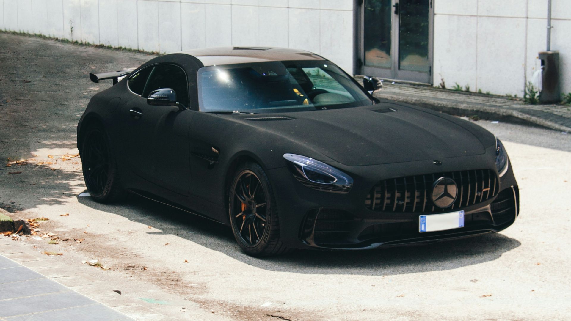 a black sports car parked in front of a building