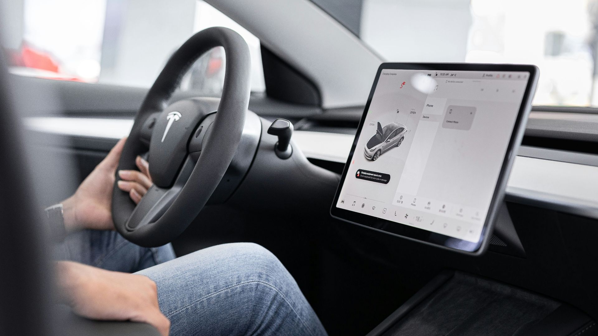 a person sitting in a car with a tablet