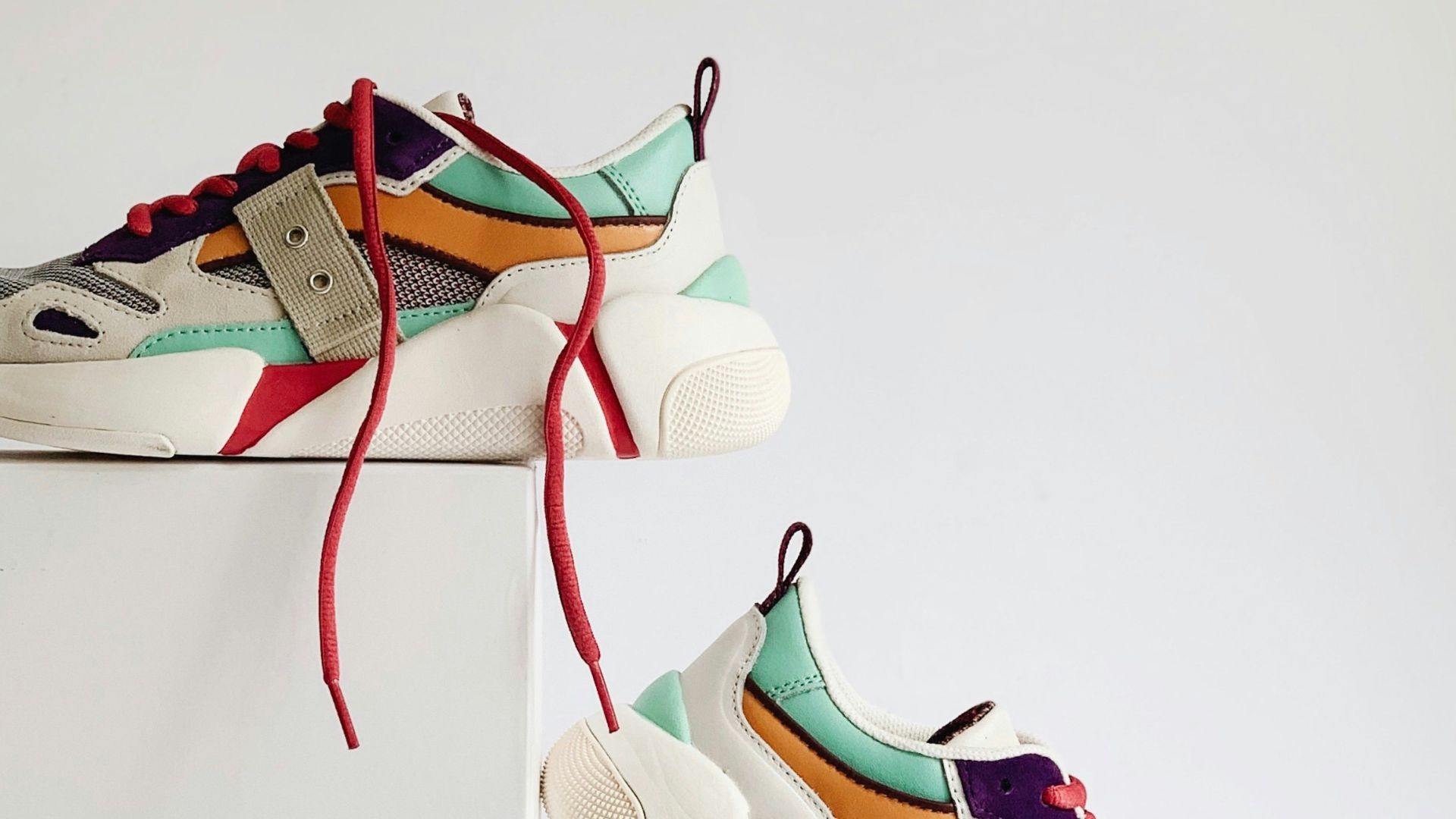 pair of white-and-orange athletic shoes on white box