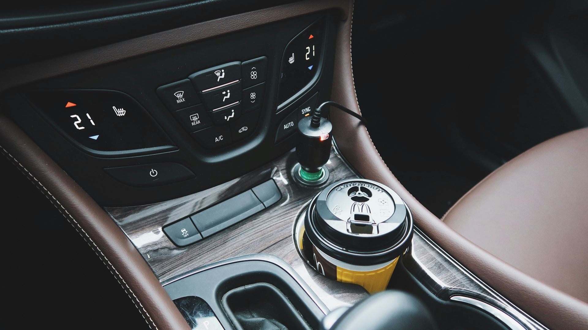 black and yellow disposable cup on car center console