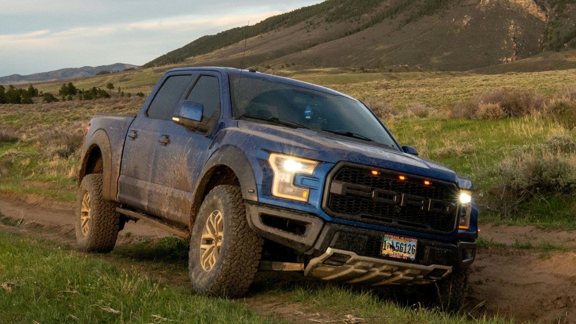 a pickup truck driving down a dirt road