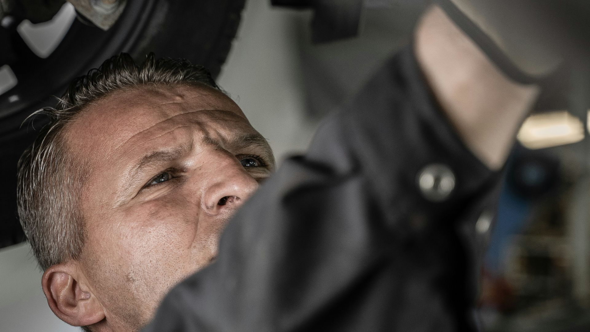 a man working on a car under a vehicle