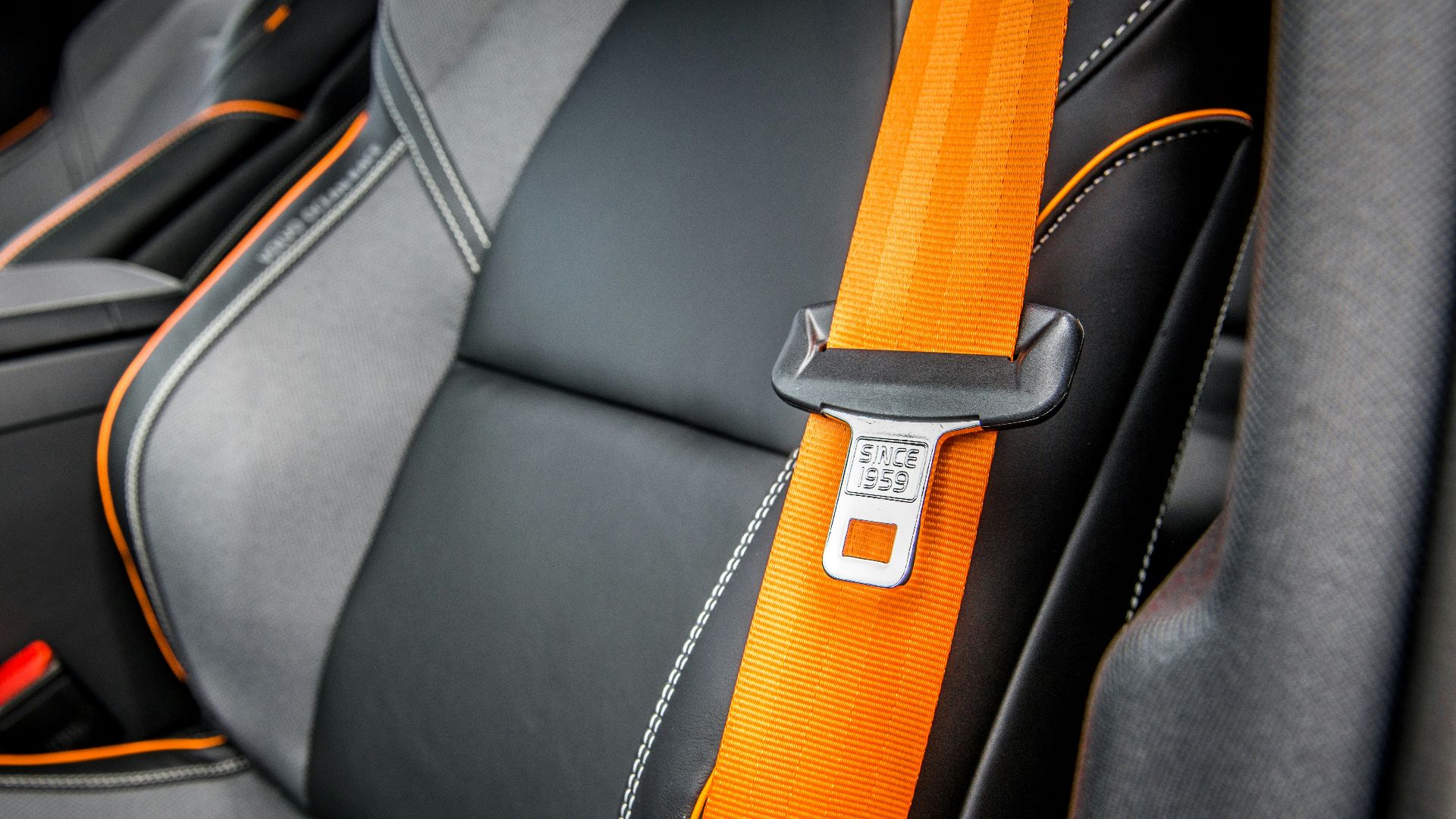 orange and white belt on black leather seat