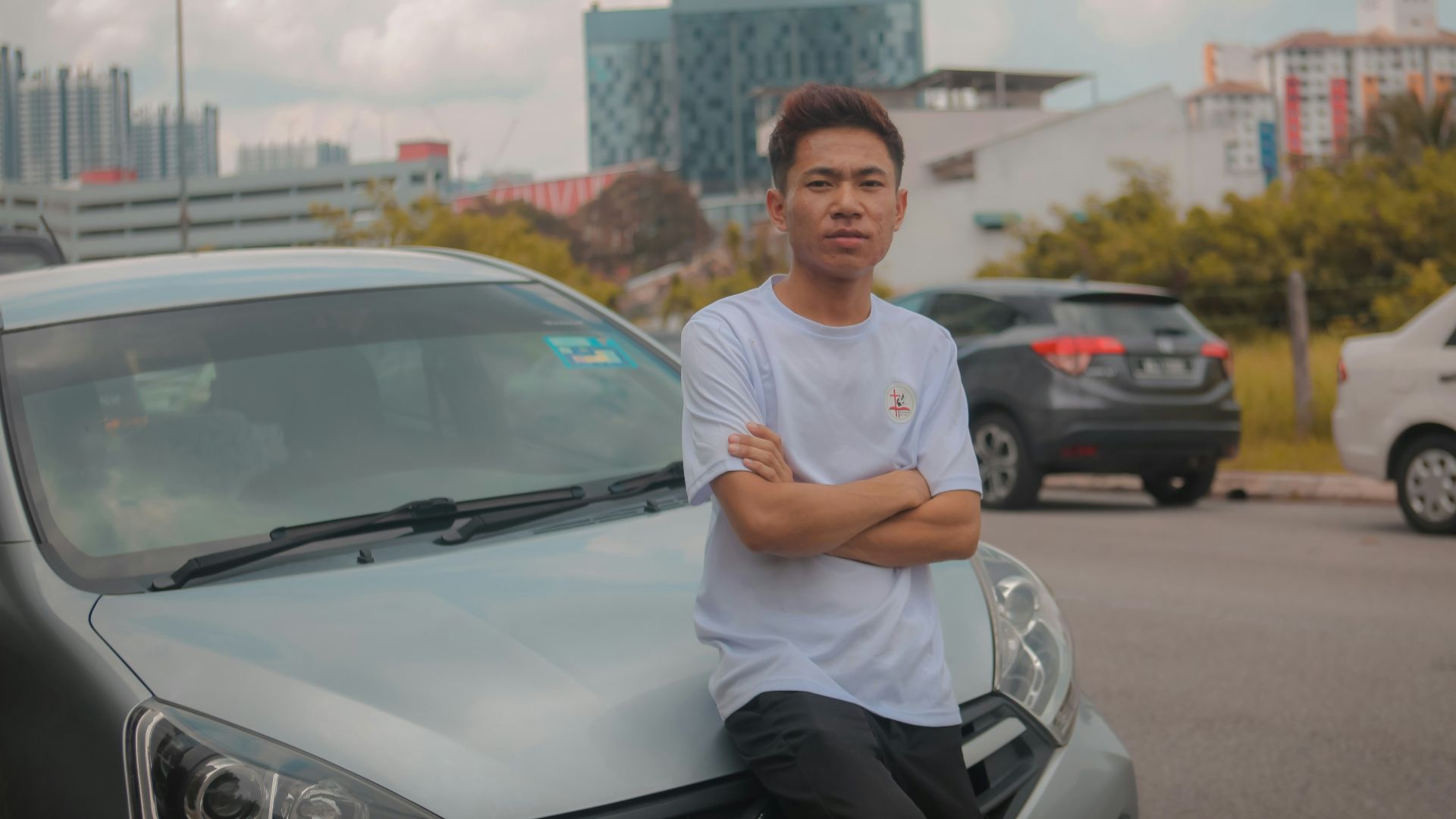 A man sitting on the hood of a car