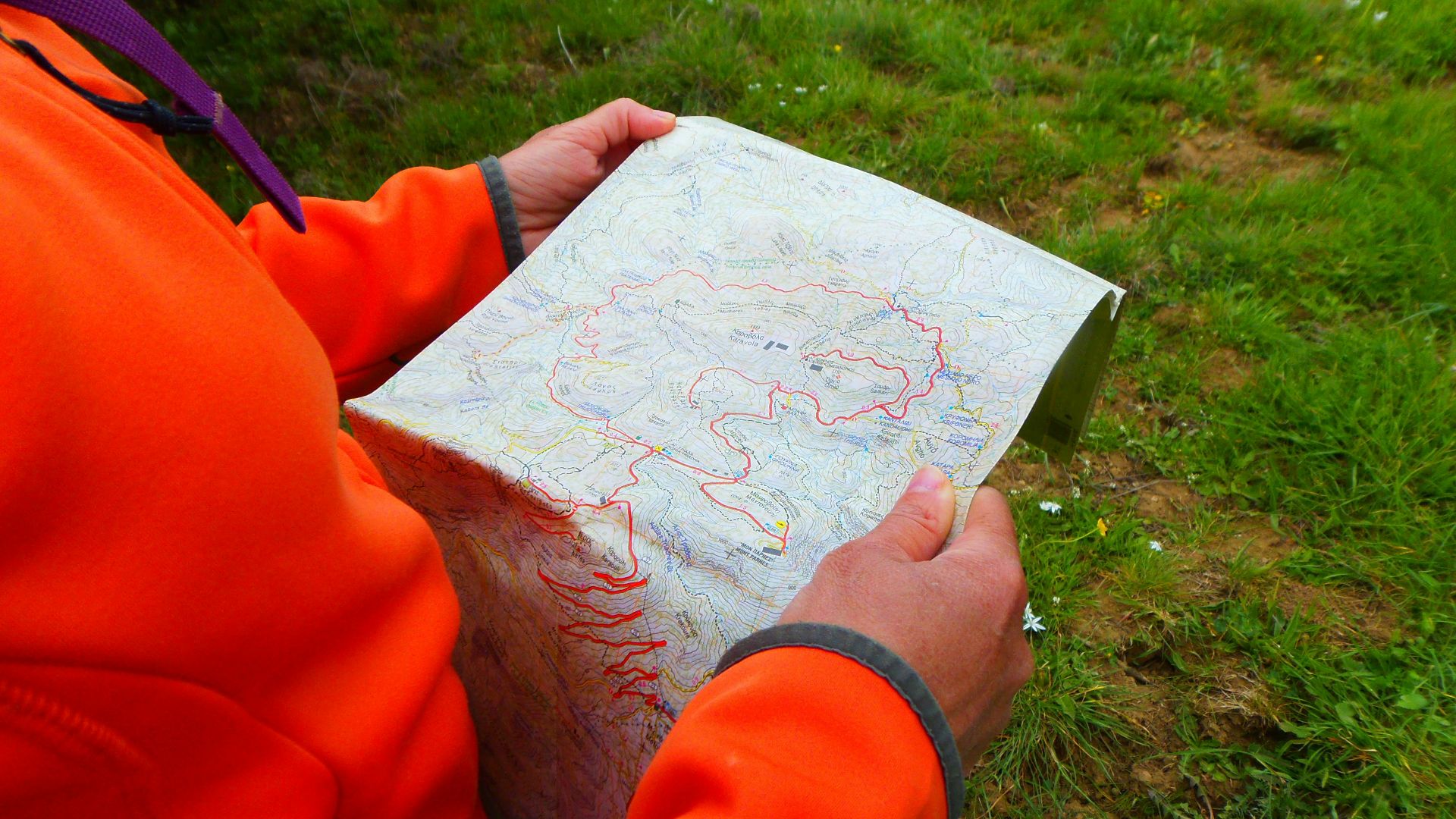 person in orange long sleeve shirt holding white printer paper