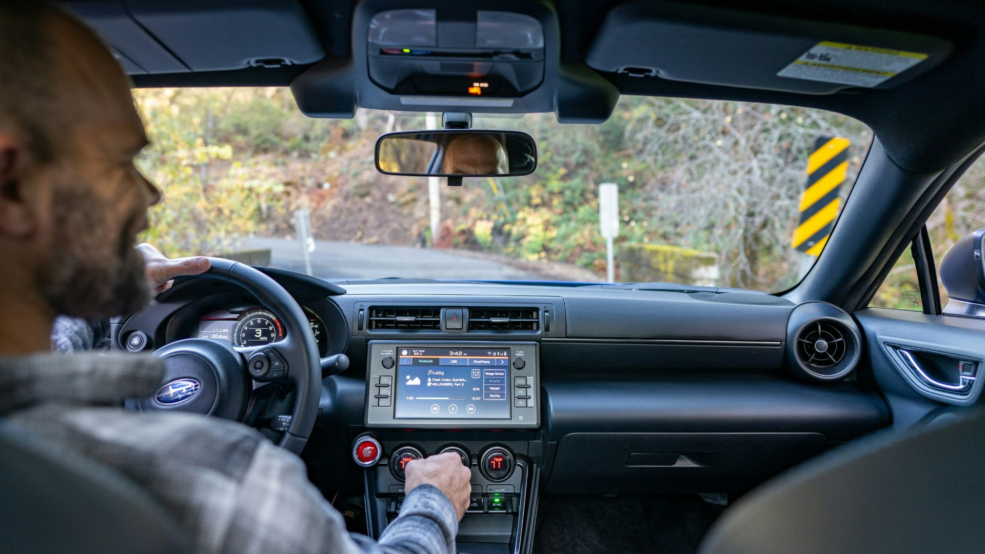 A man driving a car with a gps device in his hand