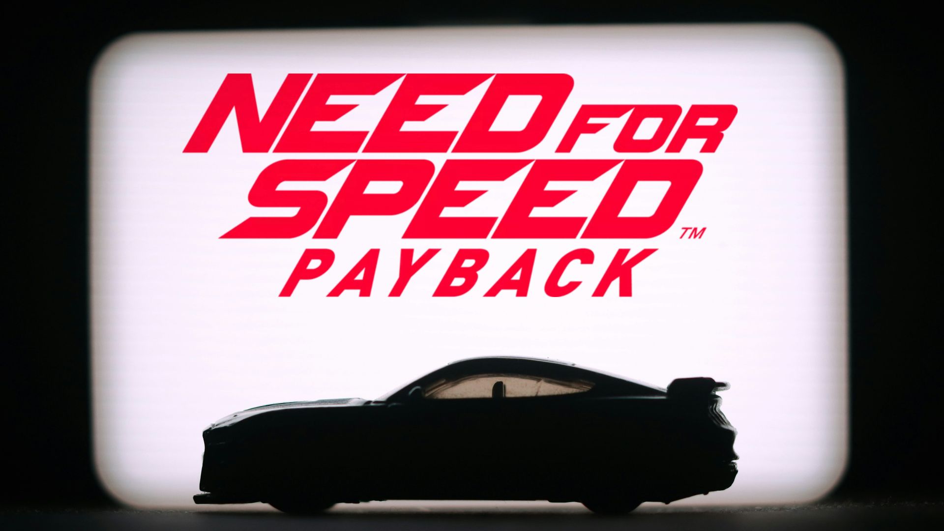 A picture of a car with a need for speed payback sign in the background