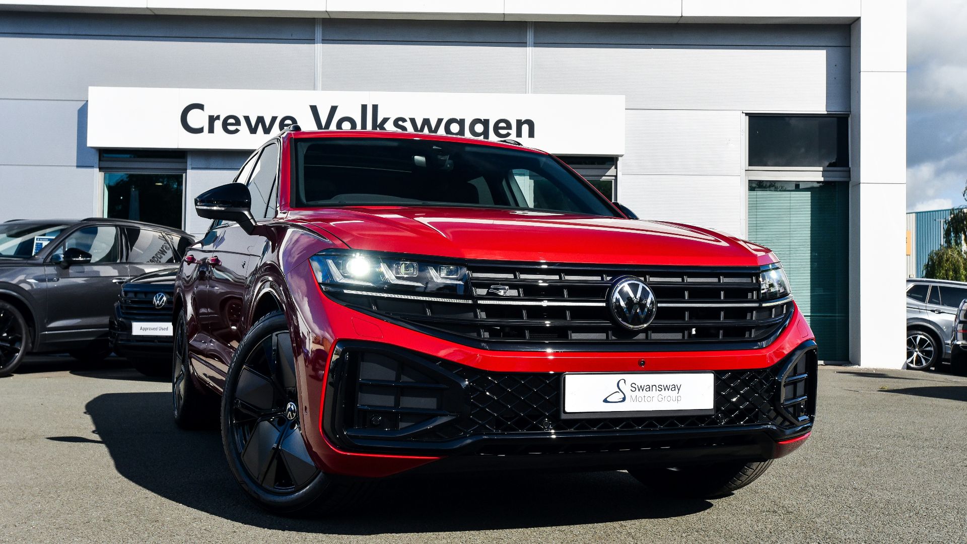 a red volkswagen suv parked in front of a building