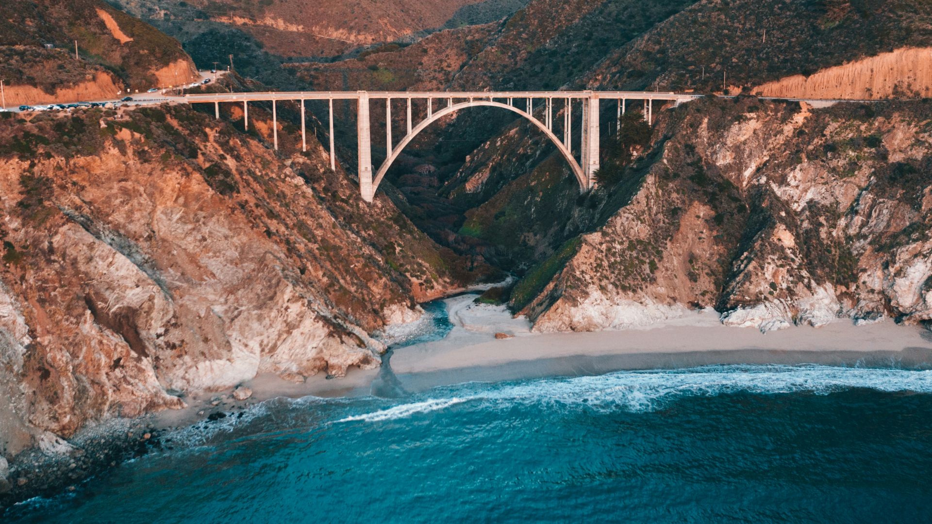 gray concrete bridge over blue sea during daytime