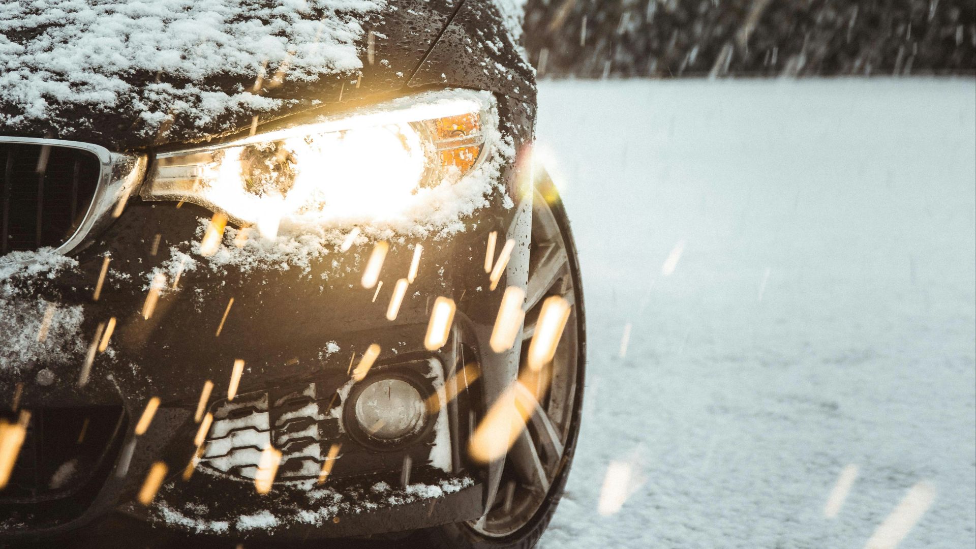black car on snow covered road during daytime