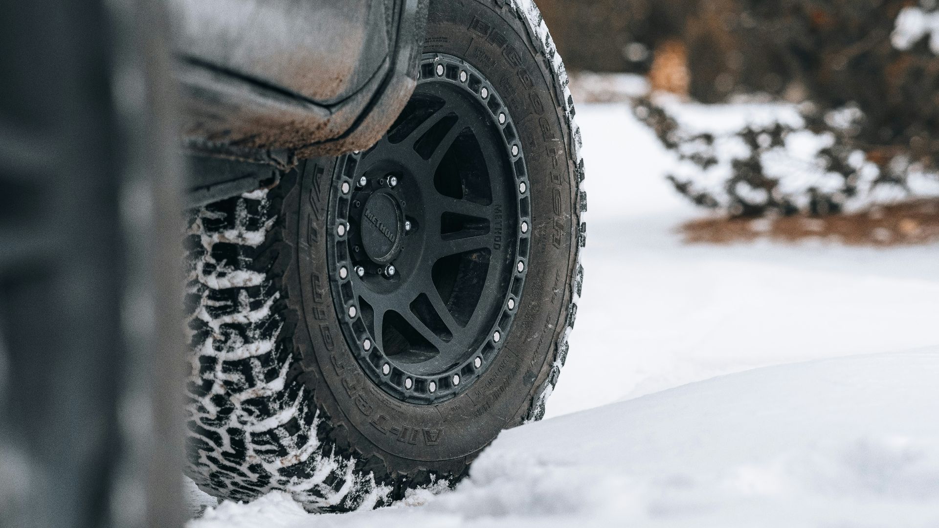 a truck is parked in the snow near some trees