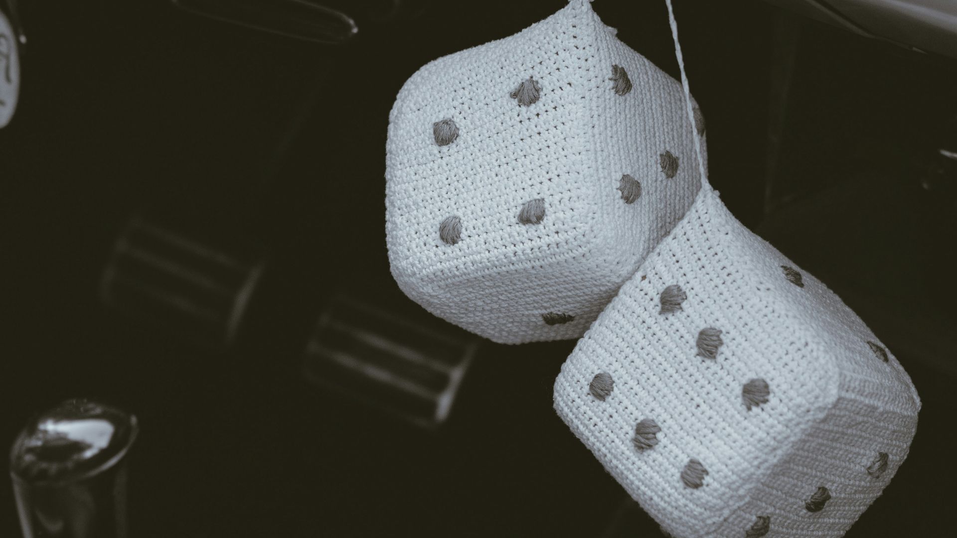 a car dashboard with two dices hanging from the dash board