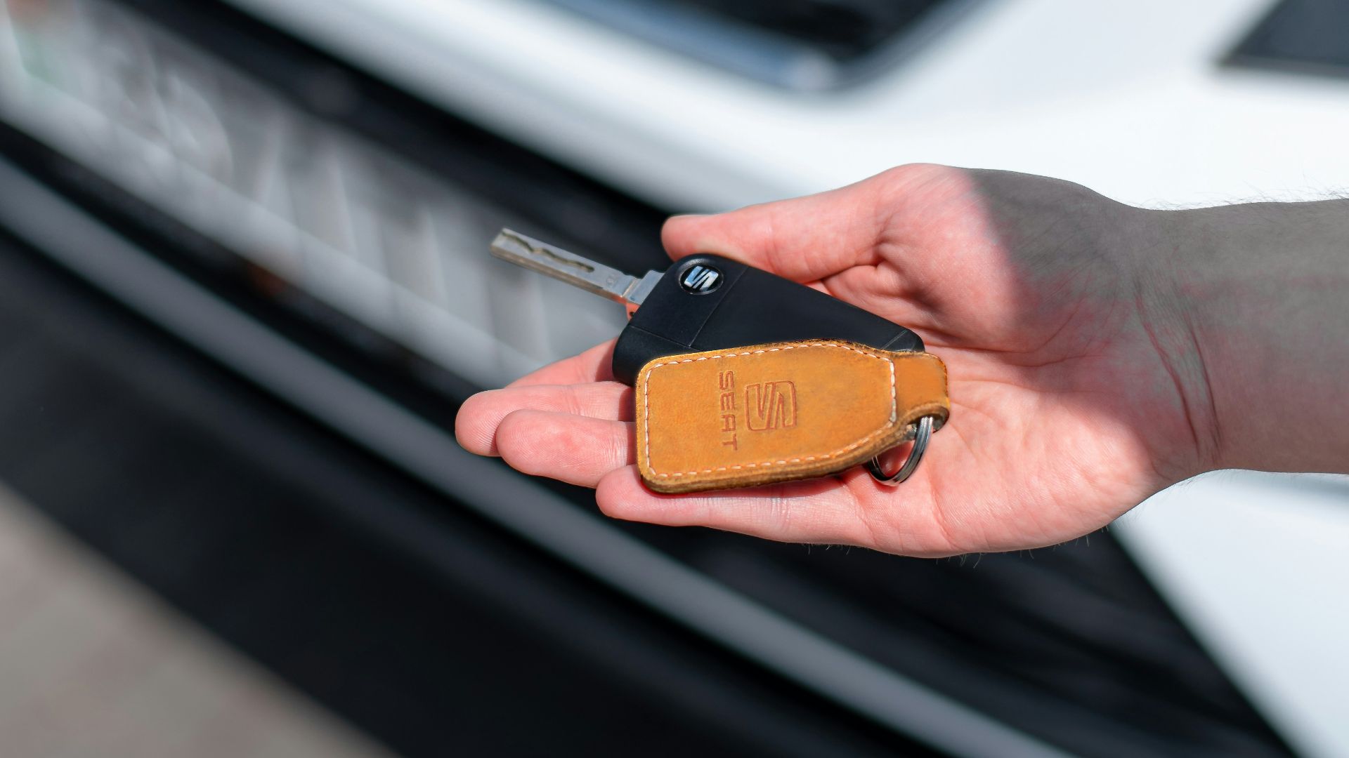 a person holding a car key in their hand