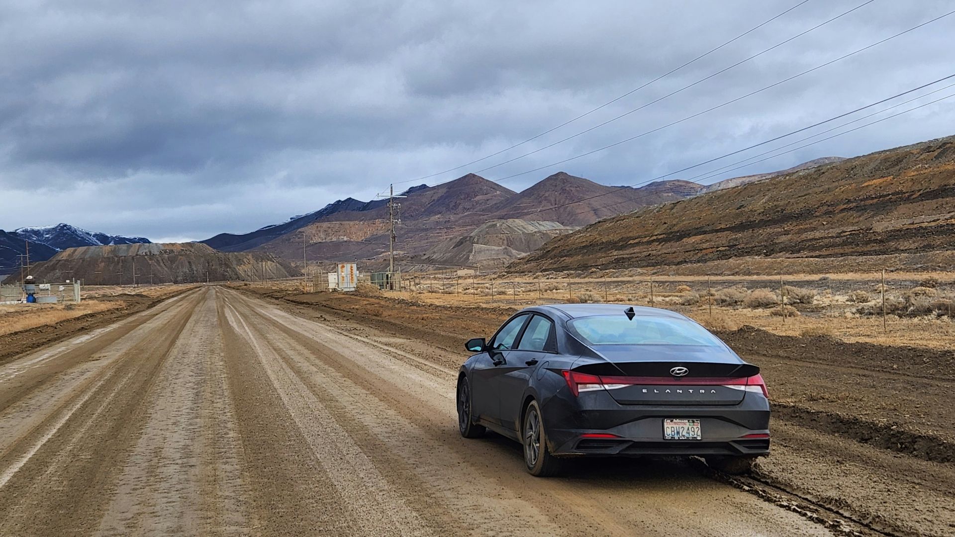 a car parked on a dirt road in the middle of nowhere