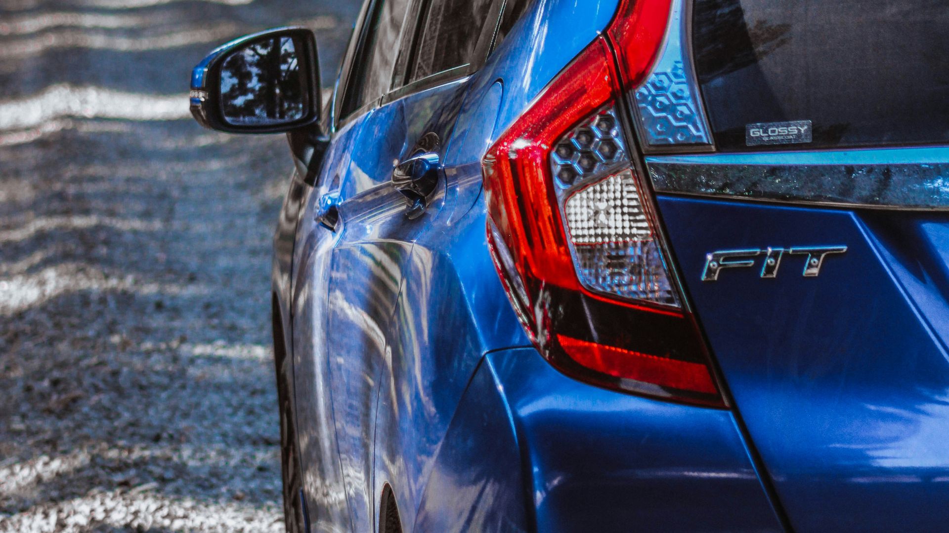 a blue car parked on a gravel road