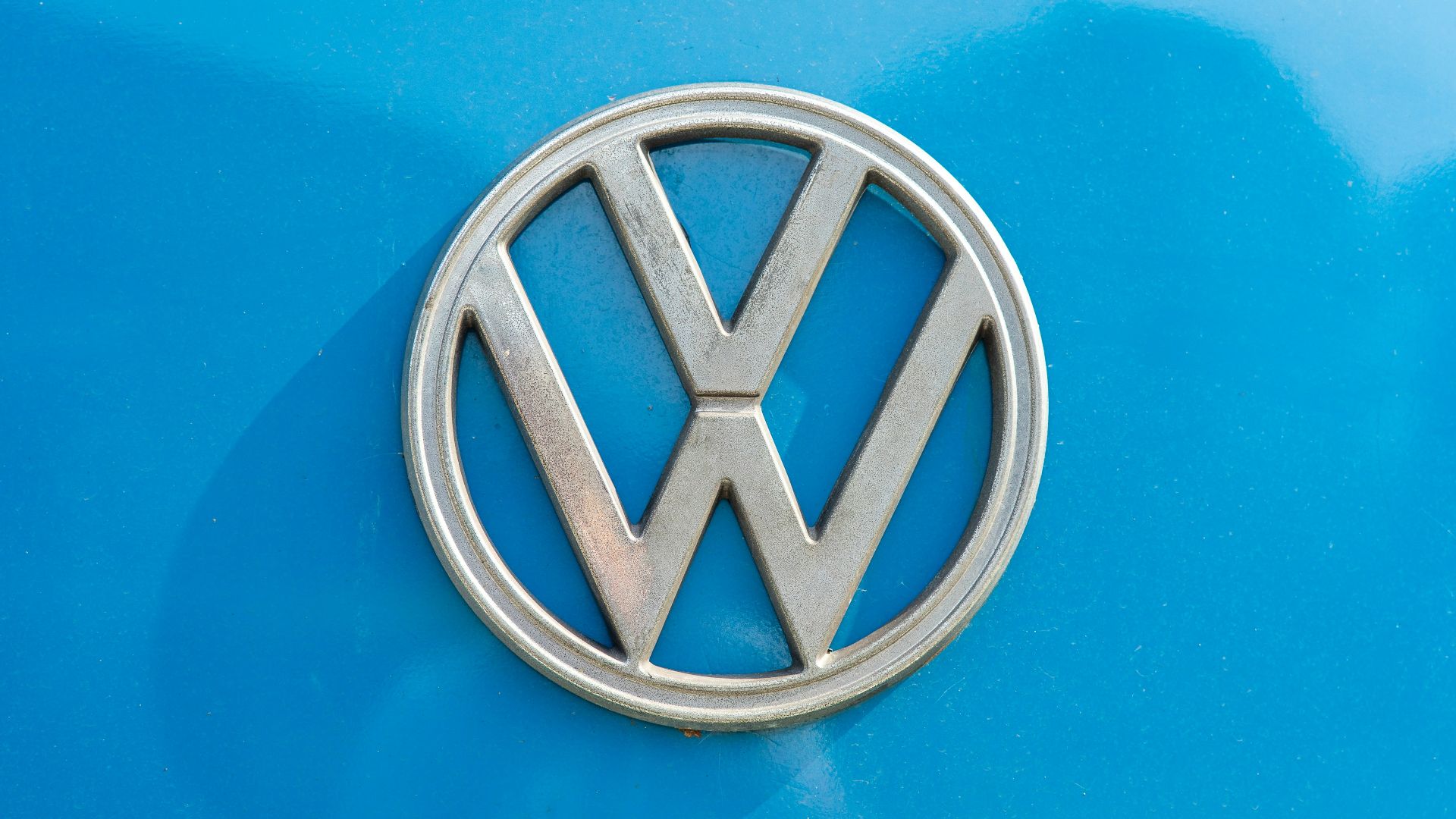 a close up of a volkswagen emblem on a blue car